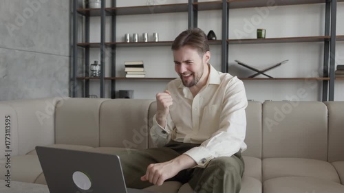 Happy Man Celebrating Victory During Online Meeting At Home