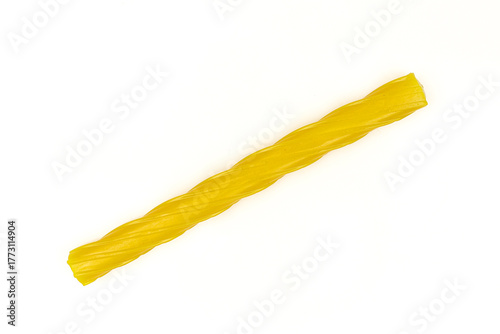 Single yellow gummy licorice stick isolated on white background. Chewy liquorice treat