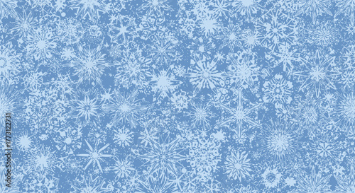 A close-up view of a light blue background filled with many small, intricate white snowflakes creating a festive wintery texture