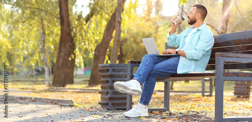 Young man with laptop drink...