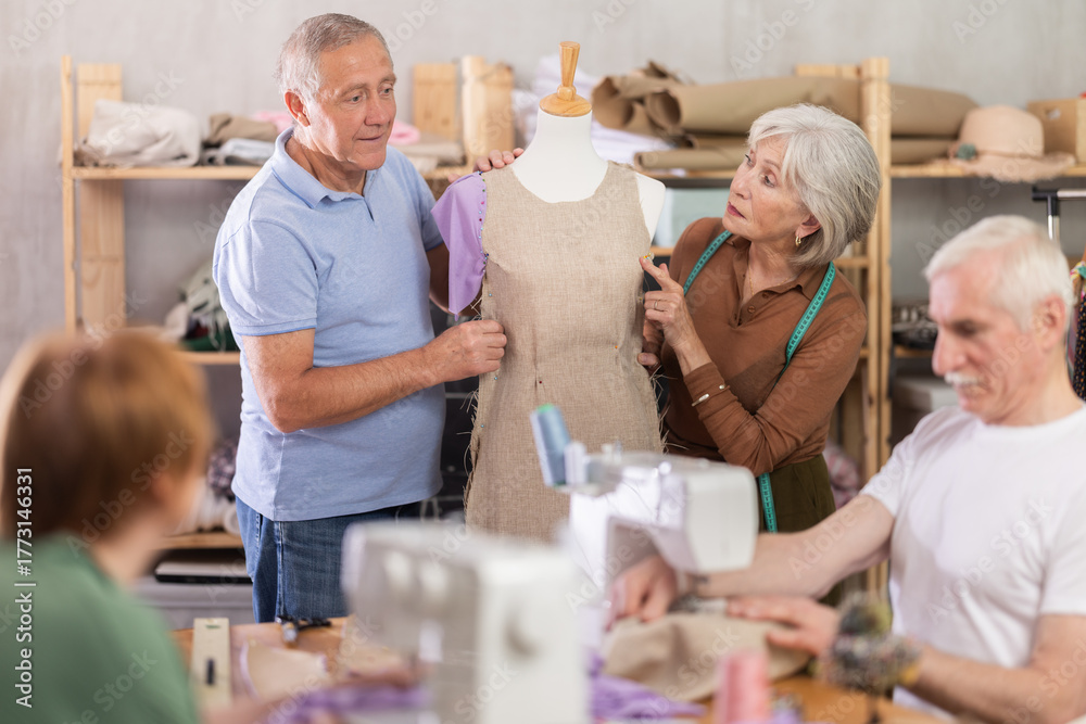 Obraz premium Group of elderly men and women sew and work with mannequin during master class