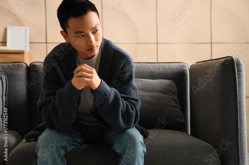 Sad young Asian man sitting...