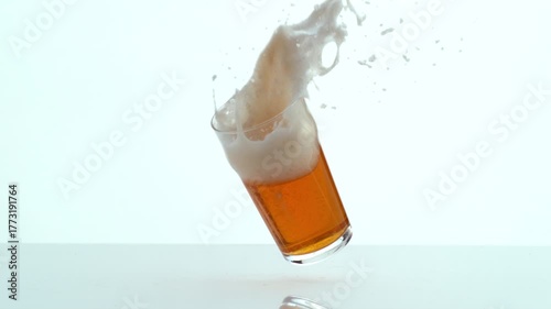 Glass of Beer falling and spilling in slow motion