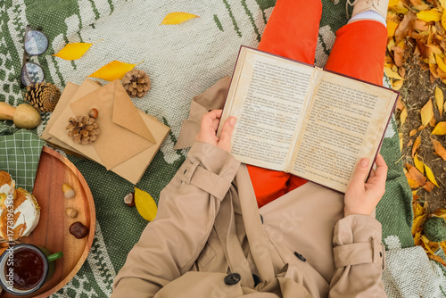 Young woman reading book on...