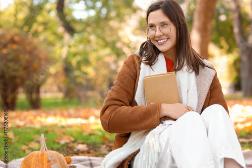 Happy young woman with book...