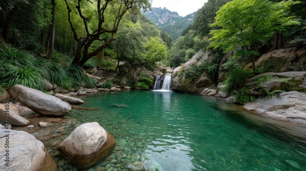 Naklejka premium Serene Natural Waterfall Cascading Into A Crystal Clear Turquoise Pool Surrounded By Lush Green Forest And Rocky Outcrops In Daylight