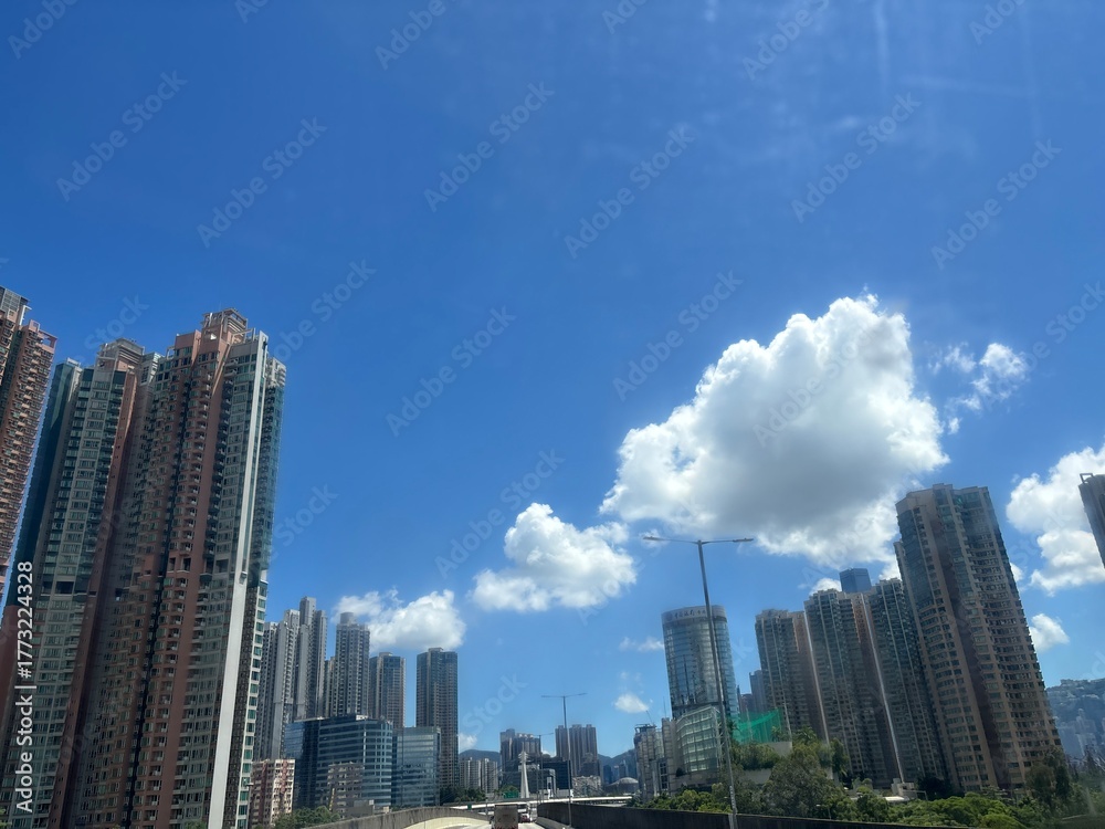 Fototapeta premium 青空と白い雲に包まれた香港の高層ビル街