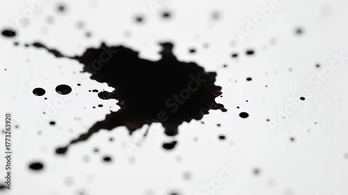 Abstract Black Ink Splatter on White Textured Paper with Macro Detail and Shallow Depth of Field