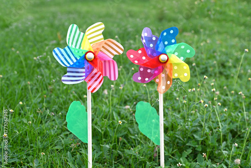 Toy windmills on a background of green grass on a Sunny summer day