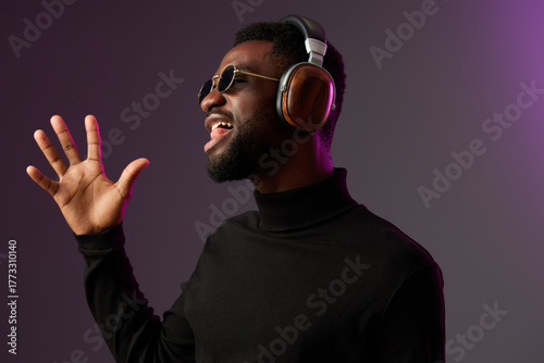 Tableau sur toile Black male model in stylish black turtleneck, wearing headphones and sunglasses,