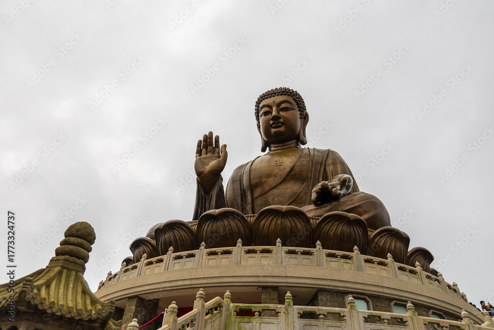 Obraz premium Giant tian tan buddha statue sitting on mountain peak in hong kong