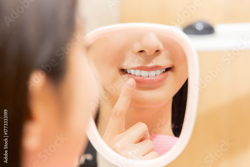手鏡で歯を確認する女性
