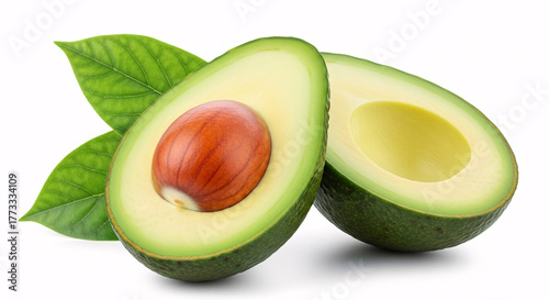 Fresh avocado cut in half with a large seed and green leaves, isolated on white background