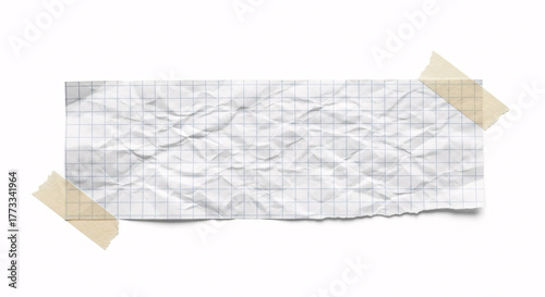 Crumpled graph paper note with grid lines taped to a white background