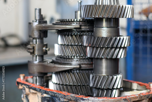 Detailed stack of helical gears and shafts from a disassembled vehicle transmission, showcasing the mechanical complexity and precision engineering of the components.