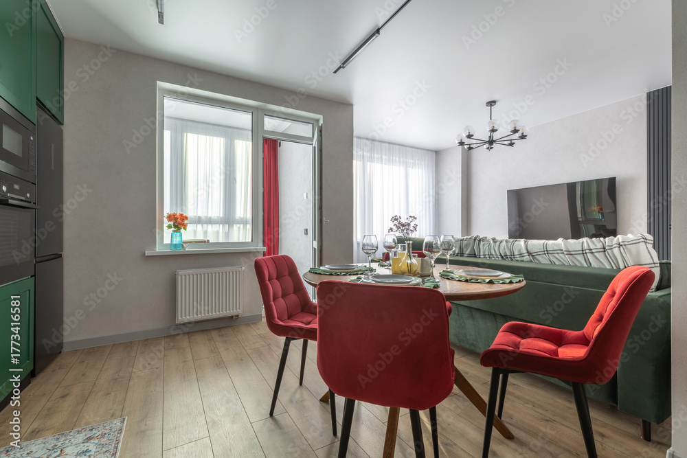 Fototapeta premium Modern Living Room and Kitchen with Red Chairs and Green Sofa