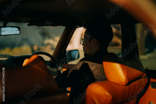 Rear view of a man driving a classic car with warm cinematic lighting, retro automotive lifestyle and nostalgic travel atmosphere.