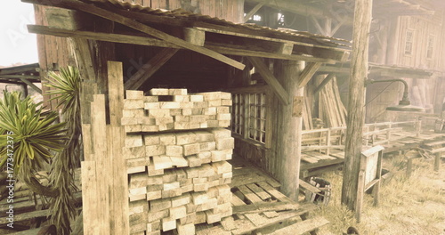 Wallpaper Mural Rough wooden planks are neatly stacked next to a weathered building surrounded by dry grass and a sparse vegetation area. The setting conveys a rustic charm. Torontodigital.ca