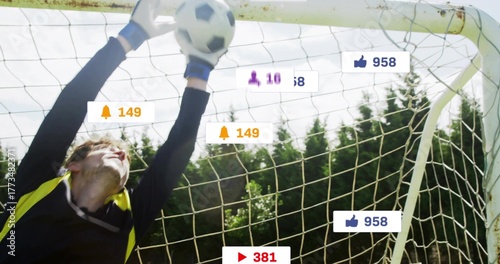Leaping goalkeeper in gloves catching soccer ball at goal net, with notification icons, copy space
