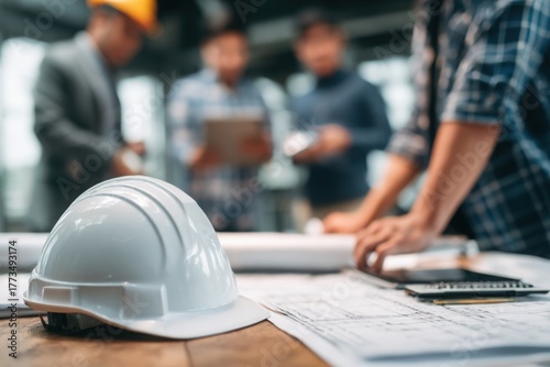 Close-up of architects' hands sketching and revising detailed floor plan on blueprint paper during project planning in office.