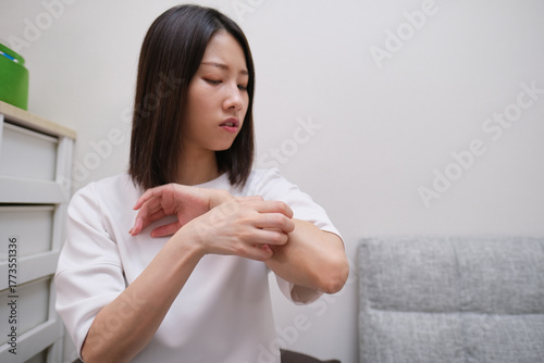 Woman scratching her arm due to skin irritation