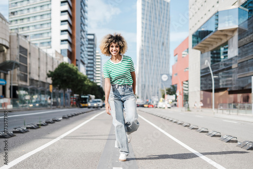 Wallpaper Mural Happy woman enjoying leisure time walking on road at city street Torontodigital.ca