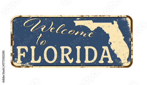 Welcome to Florida. A worn blue plaque with the name and outline of the state. Welcome inscription on the road sign