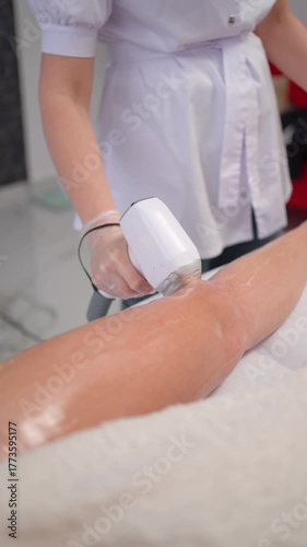 Laser hair removal on woman leg in beauty clinic, Close-up of specialist in white coat using device during cosmetic treatment session