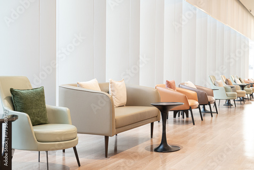 Fotografia Modern lounge seating minimalist interior soft lighting neutral color palette contemporary chairs cozy cushions clean lines wooden floor waiting area airy space