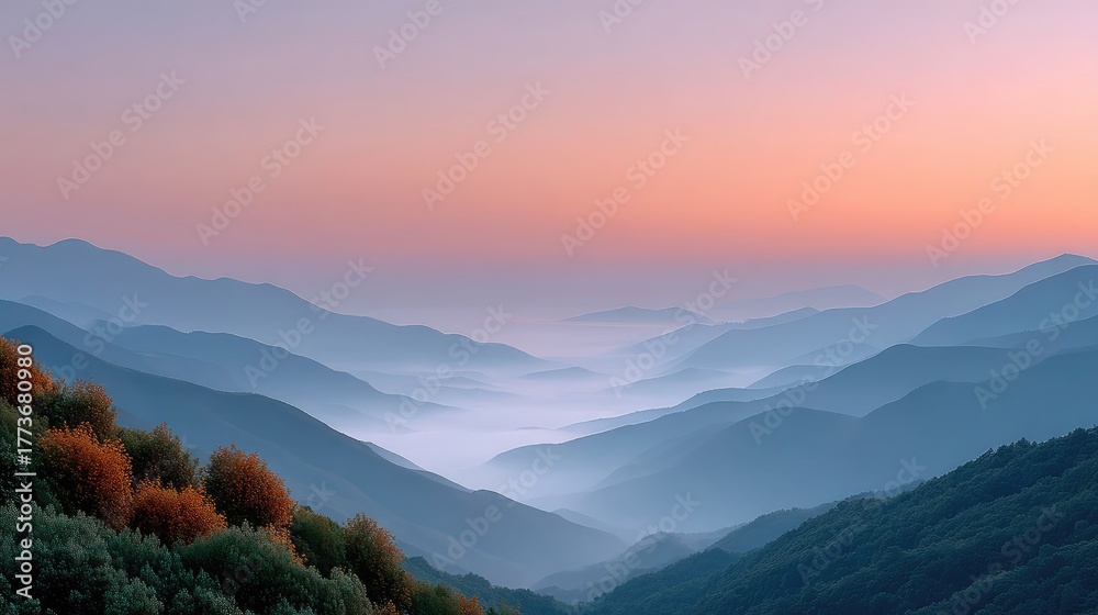 Obraz premium Serene Sunrise Over Misty Forested Hills with Golden Hues in the Sky and Gentle Blue Fog in the Valleys