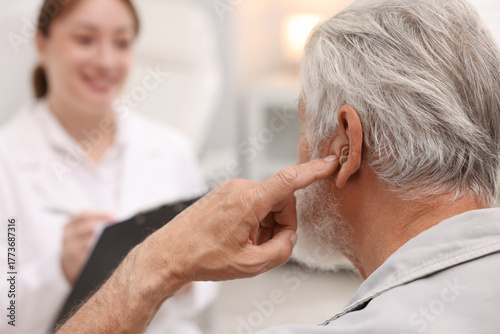 Wallpaper Mural Senior man with hearing aid and doctor working in hospital, selective focus Torontodigital.ca