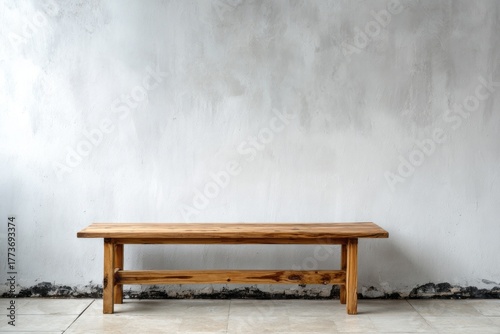 Wooden bench against a textured concrete wall and tiled floor.