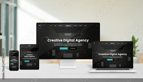 Multiple modern devices displaying creative digital agency website interface on a wooden desk, representing responsive web design and professional digital presentation
