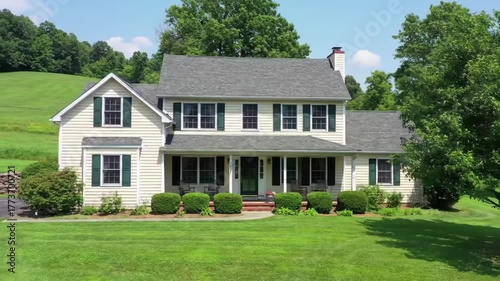 Colonial house exterior, showcasing a green lawn & trees, ideal for real estate visuals