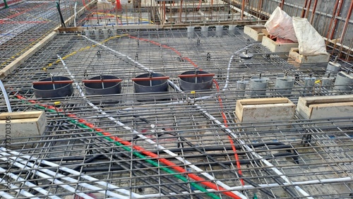 complex network of rebar, conduits, and floor drain preparations on a concrete slab