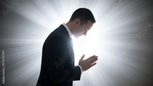 Silhouette of a person in prayer with hands clasped, glowing bright light behind him