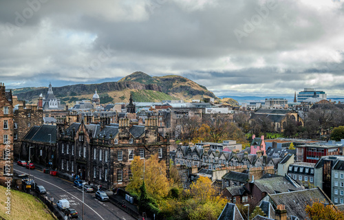 View from Edinburgh Castle overlooking charming buildings with Arthur’s Seat rising in the background amid soft autumn light - 1