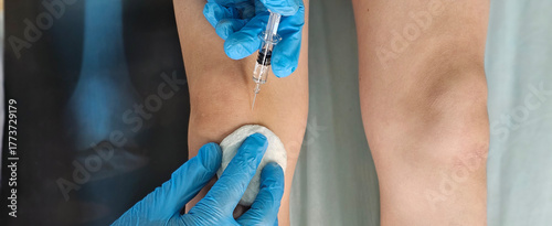 Doctor gives an injection to a patient, a child teenager, in a clinic