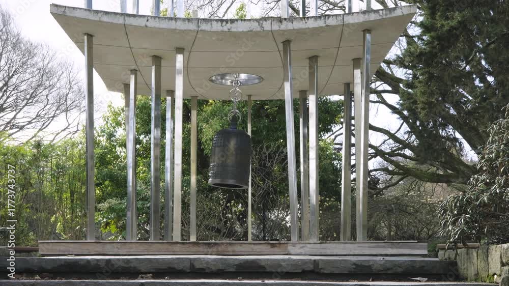 custom made wallpaper toronto digitalA Japanese style oriental giant bell, hanging and swaying under a concrete roof between metal columns in a garden environment. a 4K video clip, Christchurch botanic gardens, New Zealand.