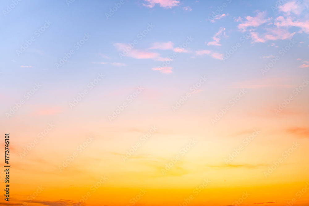 Obraz premium Sunset or sunrise sky with a vibrant gradient of orange, gold, and soft blue. Clear atmosphere with wispy clouds. Peaceful, natural light background. hope, freedom, new day and inspirational Concepts