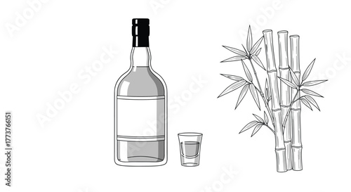 A clear glass bottle with a dark cap sits next to a small shot glass and a vase of bamboo.