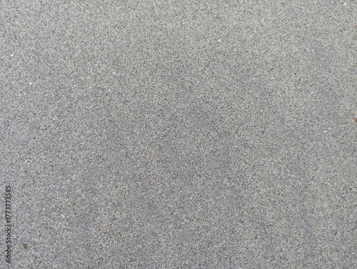 Gritty concrete surface texture with fine grain detail providing a neutral, versatile background for design projects and construction visuals