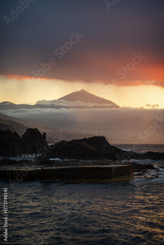 Sunset over the Atlantic Ocean with Mount Teide in the background, Tenerife, Canary Islands, Spain. Beautiful golden light illuminating the sky and sea, capturing the island’s volcanic landscape