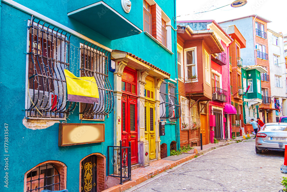 Naklejka premium Colorful houses in the Balat and Fener districts. Tourists stroll the narrow streets.