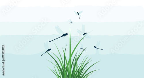 Elegant dark and translucent dragonflies flit and perch on a vibrant tuft of green grass, creating a serene natural scene against a soft blue and white striped background.