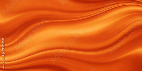 Softly flowing golden and orange silk fabric creates an abstract texture background with a smooth satin wave pattern