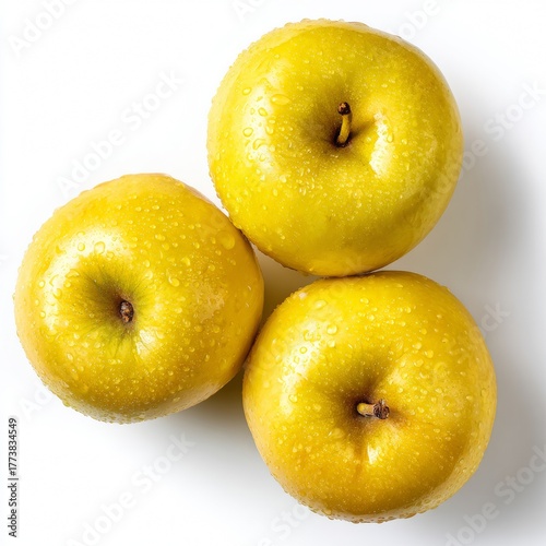 Three ripe, golden apples stacked atop one another, each with a water droplet coating. The image is of freshness and nature's bounty