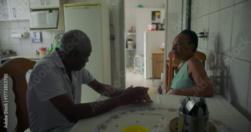 Fotografía Elderly couple of African descent sharing a thoughtful moment at a dining table,