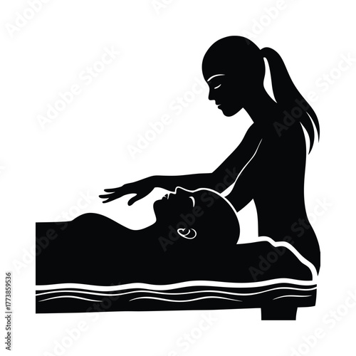 Silhouette of woman giving massage to person lying on massage table therapist client