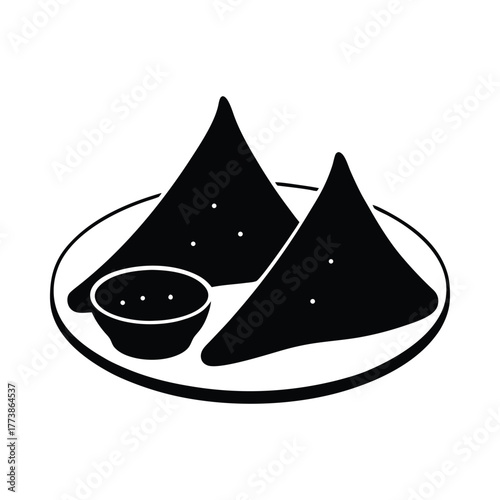 Two black triangular samosas and dipping sauce on a plate food snack